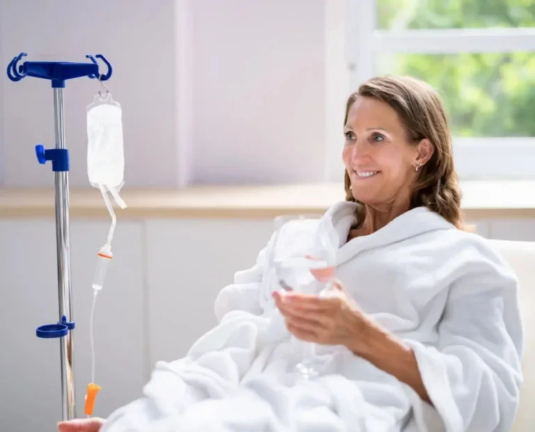 Smiling woman sitting ready for wellness treatment.